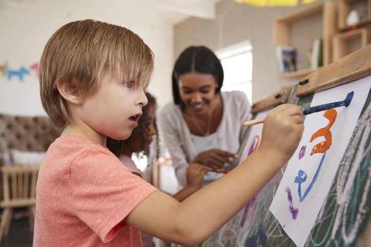 Nanny helping children with art