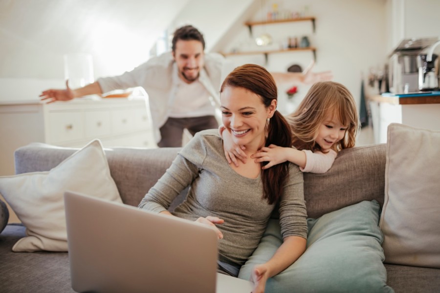 Familie zu Hause mit Mutter am Computer